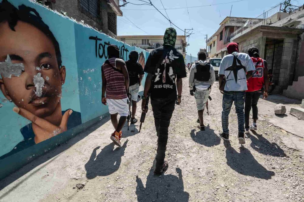 O líder do gangue Jimmy 'Barbecue' Cherizier patrulha as ruas com membros do gangue G-9 na área de Delmas 3, em 22 de fevereiro de 2024, em Port-au-Prince, Haiti. Houve uma nova onda de violência em Port-au-Prince, onde, segundo estimativas da ONU, os gangues controlam 80% da cidade. Foto de Giles Clarke/Getty Images.