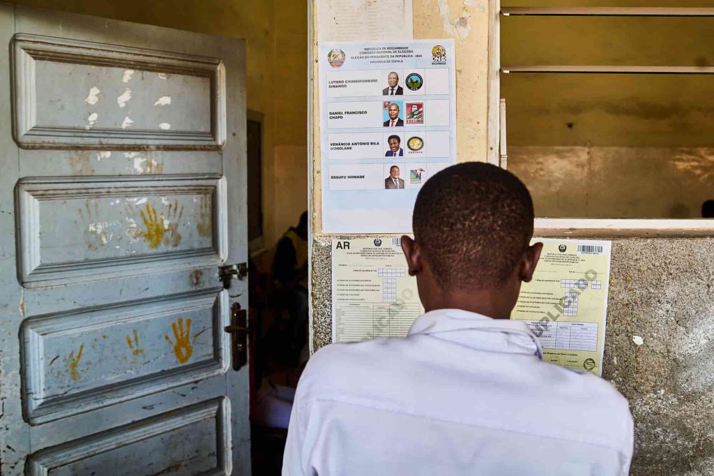 Um homem olha para os resultados das eleições afixados no exterior de uma sala de aula utilizada como assembleia de voto na Beira, a 10 de outubro de 2024, no dia seguinte às eleições nacionais em Moçambique. Foto de ZINYANGE AUNTONY/AFP via Getty Images.