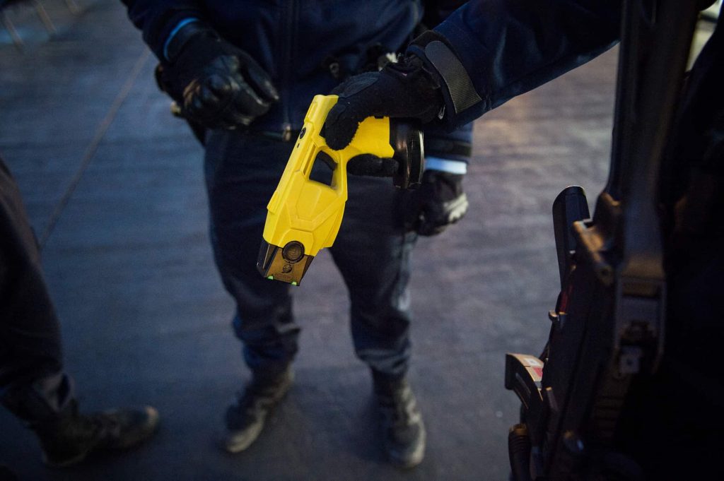 Um polícia francês segura um taser enquanto patrulha o mercado de Natal em Tours, no centro de França, a 23 de dezembro de 2016. Foto de GUILLAUME SOUVANT/AFP via Getty Images